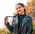 woman in black leather jacket standing near green plants during daytime